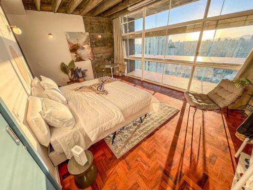 ein Schlafzimmer mit einem Bett und einem großen Fenster in der Unterkunft Vem pro Copan in São Paulo