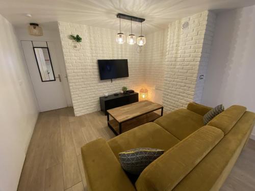 a living room with a couch and a tv at Green Factory by Plaza - Proche Disneyland Paris in Magny-le-Hongre