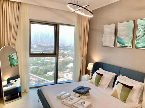 um quarto com uma cama grande e uma janela grande em Luxurious 1-bedroom With Skyline View In Downtown Views Ii em Dubai