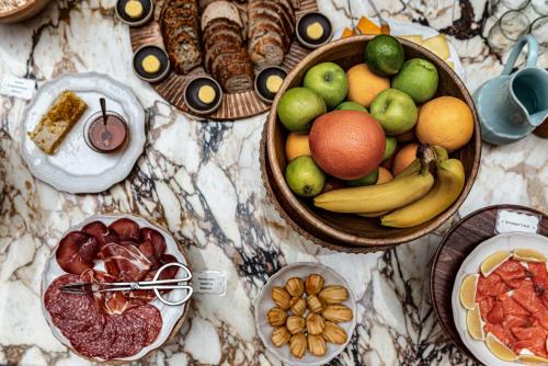 a table with bowls of fruit and plates of food at Cowley Manor Experimental in Cheltenham
