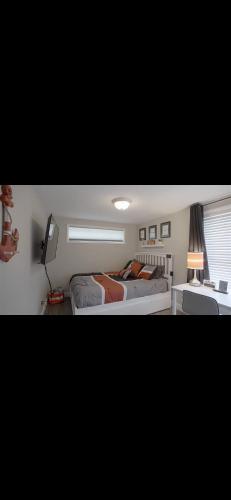 a bedroom with two beds and a desk with a lamp at Luxury Lakehouse on Oneida Lake in Blossvale