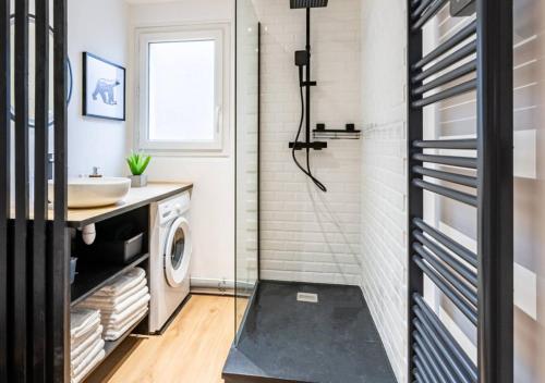 a bathroom with a sink and a washing machine at Le Carrousel Avec Parking Privé in Dijon