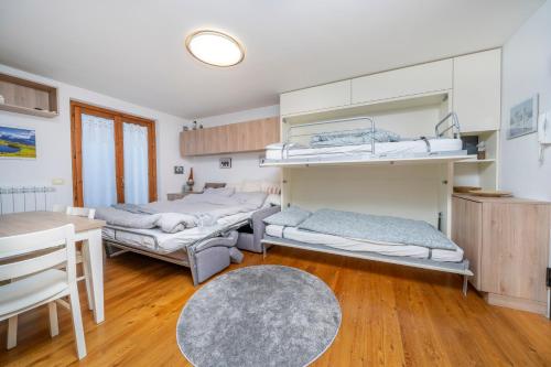 Habitación con 2 camas y mesa. en Small & Charming Apt - Overlooking the Alps, en Tarvisio