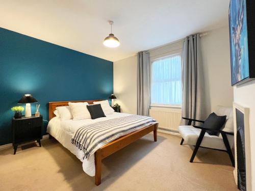 una camera con letto e parete blu di CHARMING WINDSOR COTTAGE, INCREDIBLE Location, Free Residents Parking, Castle Doorstep a Windsor