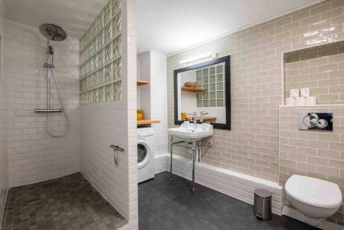 W łazience znajduje się toaleta, umywalka i pralka. w obiekcie Secret APT with Garden 6/8P Montmartre Sacré-Coeur w Paryżu
