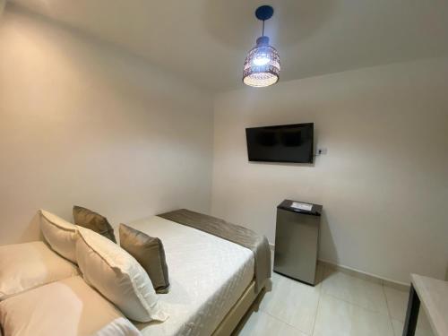 a bedroom with a bed and a tv and a couch at Maidy Luxury Hotel in Medellín