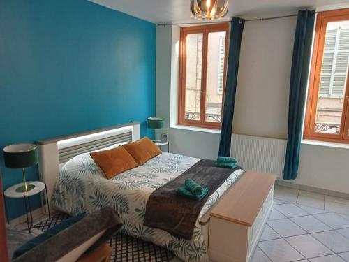 - une chambre avec un lit aux murs bleus et des fenêtres dans l'établissement Perle Rare F1 de 43 m quartier historique.(3 p), à Moulins