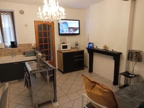 a living room with a tv on the wall and a table at Perle Rare F1 de 43 m quartier historique.(3 p) in Moulins