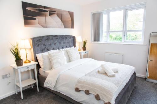 a bedroom with a bed and two windows at Cozy Townhouse in the heart of Greater Manchester in Manchester
