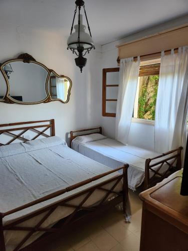 a bedroom with two beds and a mirror and a window at Apart Hotel Sahara in Pinamar