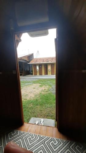 an open door with a view of a building at Cabana com Ar condicionado e area de cozinha e banheiro compartilhado a 10 minutos do Parque Beto Carrero in Penha