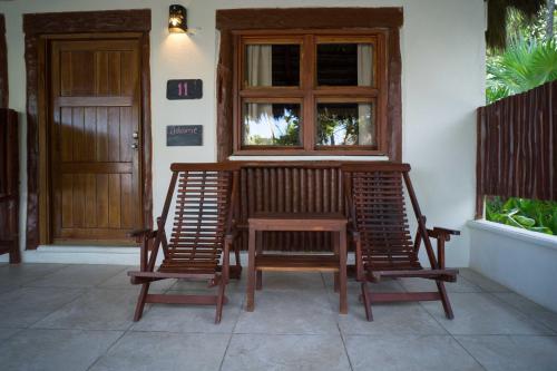 um alpendre com 2 cadeiras, uma mesa e uma janela em BT Live Tulum located at the party zone em Tulum