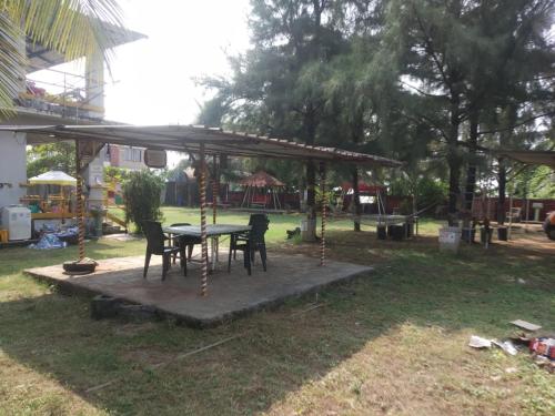 a table and chairs under a pavilion in a yard at SAMARA SEAVIEW in Alibag