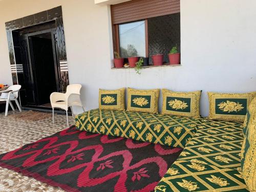 1 dormitorio con cama y alfombra en Villa avec piscine à louer aux environs de Birjdid 46km km de Casablanca route d'El Jadida, en Bir Jedíd Saint-Hubert