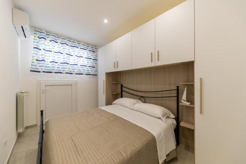 a bedroom with a bed and white cabinets at Plume Apartment by Wonderful Italy in Bari