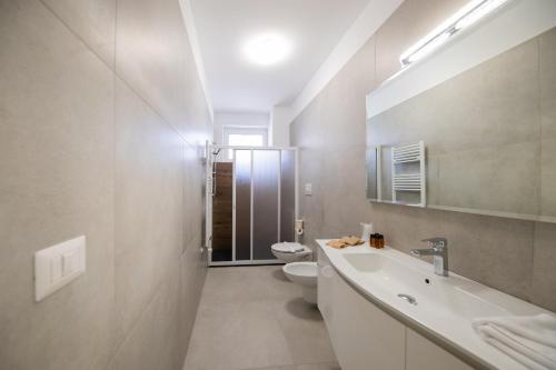 a white bathroom with a sink and a toilet at Plume Apartment by Wonderful Italy in Bari