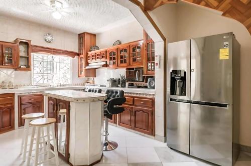 uma cozinha com armários de madeira e um frigorífico de aço inoxidável em Joyful Ambiance Retreat 