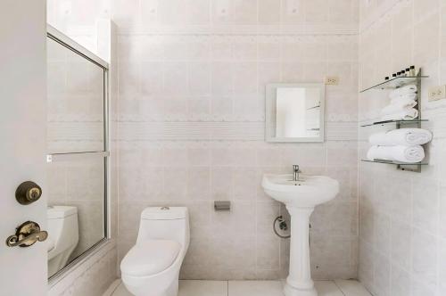 a white bathroom with a toilet and a sink at Joyful Ambiance Retreat in Bushy Park