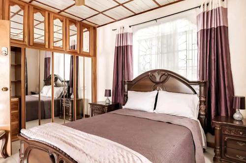 Schlafzimmer mit einem Bett und einem Fenster mit Vorhängen in der Unterkunft Joyful Ambiance Retreat 