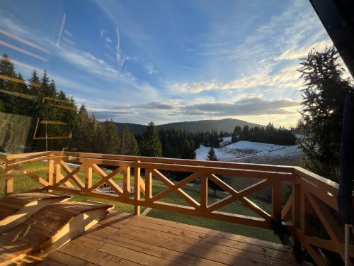 um deque de madeira com vista para as montanhas em Hanina Village Resort - l i ll em Čajniče