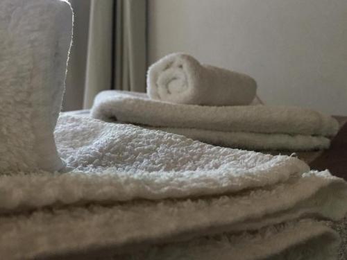 una pila de toallas sentadas encima de una cama en Casitas Santa Elena en Trapiche