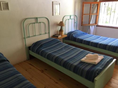 1 dormitorio con 2 camas con sábanas azules y blancas en Casitas Santa Elena en Trapiche