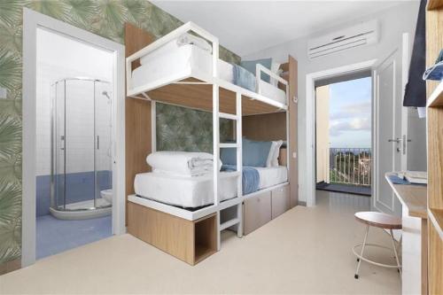 a bedroom with a bunk bed and a bathroom at Unconventional Sorrento Coast in Sant'Agnello