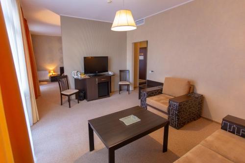 a living room with a couch a table and a tv at Аполлонія in Poltava