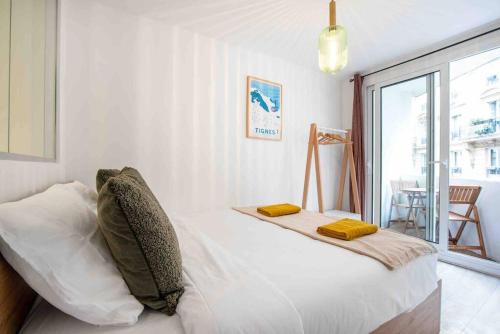 Un dormitorio con una cama con dos almohadas encima. en Porte MAILLOT, CHAMPS ÉLYSÉES, TRIOMPHE, suite 3 chambres 8P, en París