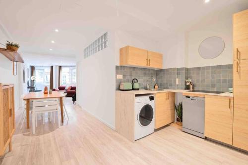 une cuisine avec un lave-linge et une table. dans l'établissement Porte MAILLOT, CHAMPS ÉLYSÉES, TRIOMPHE, suite 3 chambres 8P, à Paris