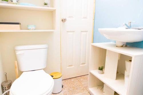 a bathroom with a white toilet and a sink at Acogedor Loft, Playa Las Flores in La Libertad