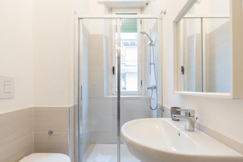 a white bathroom with a sink and a shower at Duomo - Citylife Pink Vintage APT center Milan in Milan