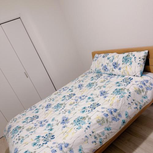 Un dormitorio con una cama con flores azules. en Free Parking Namba south Villa 4 rooms 120m2 en Osaka