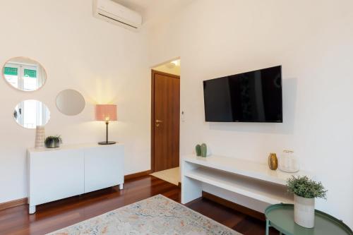 a living room with a tv on a white wall at Duomo - Citylife Pink Vintage APT center Milan in Milan