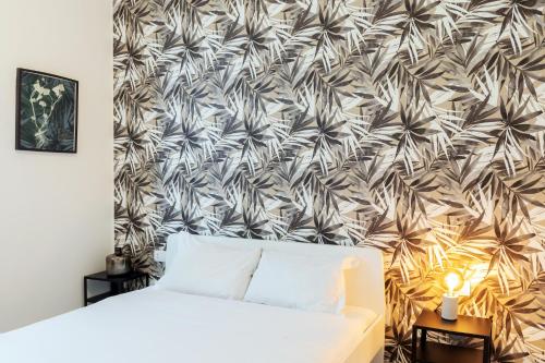 a bedroom with a bed and a wall with a wallpaper at Duomo - Citylife Pink Vintage APT center Milan in Milan