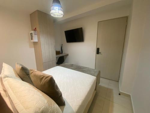 a small bedroom with a bed and a television at Maidy Luxury Hotel in Medellín