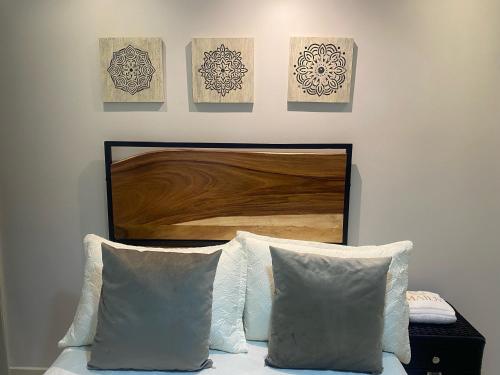 a bed with two pillows and paintings on a wall at Maidy Luxury Hotel in Medellín