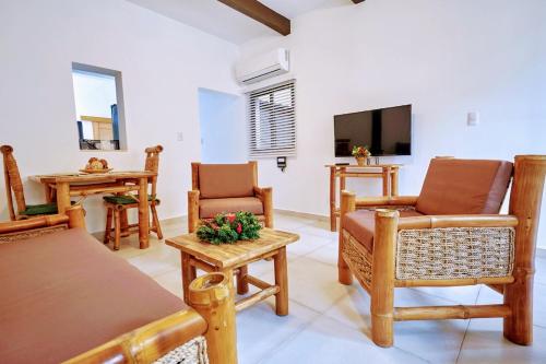 a living room with wooden furniture and a flat screen tv at Heritage Residences Santo Domingo in Santo Domingo