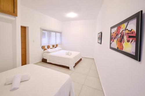 a bedroom with two beds and a painting on the wall at Heritage Residences Santo Domingo in Santo Domingo