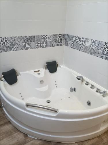 bañera blanca en una habitación con azulejos en Jacuzzi Barcala, en Valga