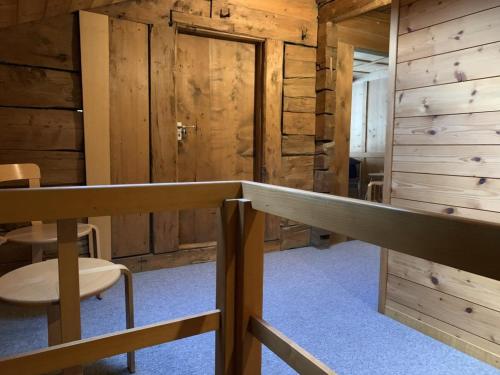 Habitación con paredes de madera, mesa y sillas. en Revier musisch und historisch, en Diesbach