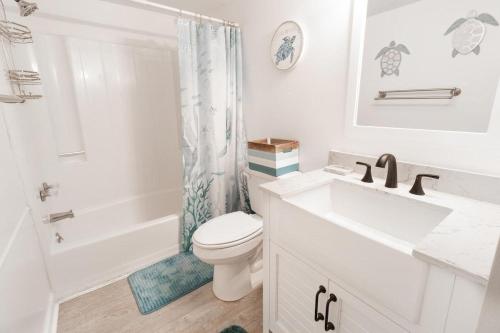 uma casa de banho branca com um WC e um lavatório em Marsh View Condo with an Indoor Pool Hot Tub em Myrtle Beach