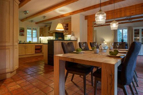 a kitchen and dining room with a wooden table and chairs at Exklusives Holzhaus in Burg