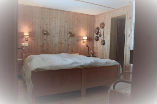 a bedroom with a bed and a wooden wall at Revier Sytli im Höcheli in Braunwald