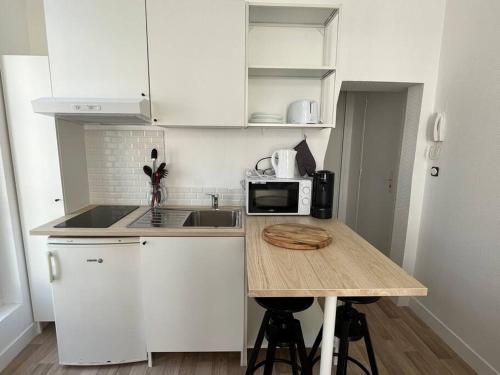 a small kitchen with a counter top with a microwave at Iris YourHostHelper in Caen