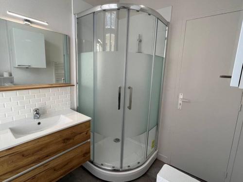a glass shower in a bathroom with a sink at Iris YourHostHelper in Caen