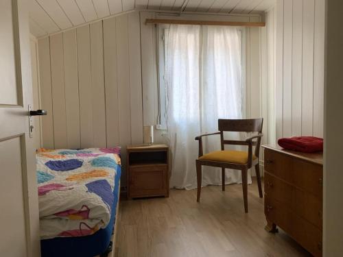 ein Schlafzimmer mit einem Bett, einem Stuhl und einem Fenster in der Unterkunft Revier Grosi's Art in Netstal