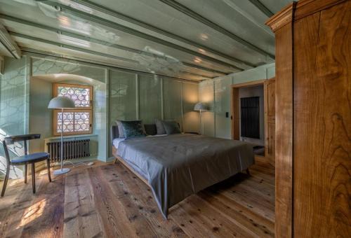 a bedroom with a bed and a table and a window at Revier Baudenkmal Beuge in Näfels