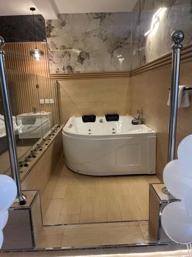 a large bath tub in a bathroom with a sink at فندق راية الشلال in Hafr Al-Batin