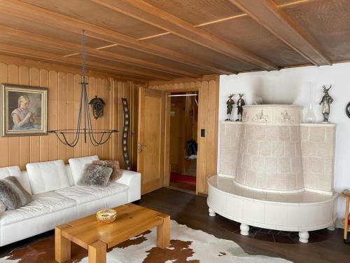 a living room with a white couch and a table at Revier Seebueb am Waldhausweg in Braunwald